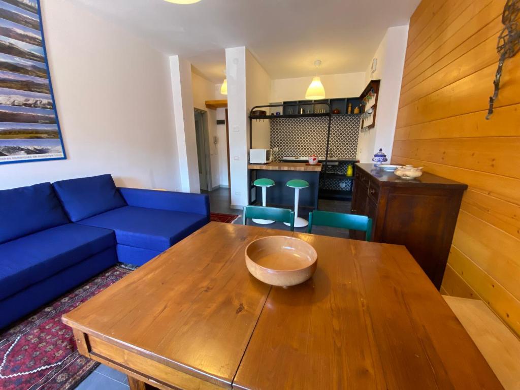 a living room with a blue couch and a wooden table at Casa Silvia in Abetone