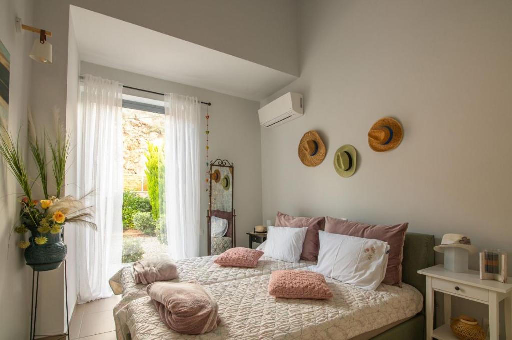 La Casa Del Sol Villa في Aegenitissa: غرفة نوم بسرير ومخدات ونافذة