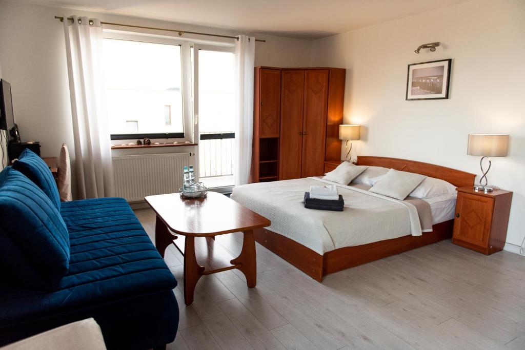1 dormitorio con cama, sofá y mesa en Villa Plazowa 6, en Rewa