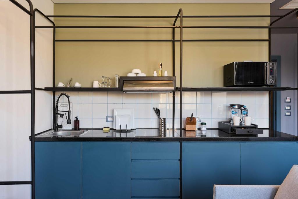 a kitchen with blue cabinets and a black counter top at Brassbell l DT l Hannaux l Tahrir sq in Cairo