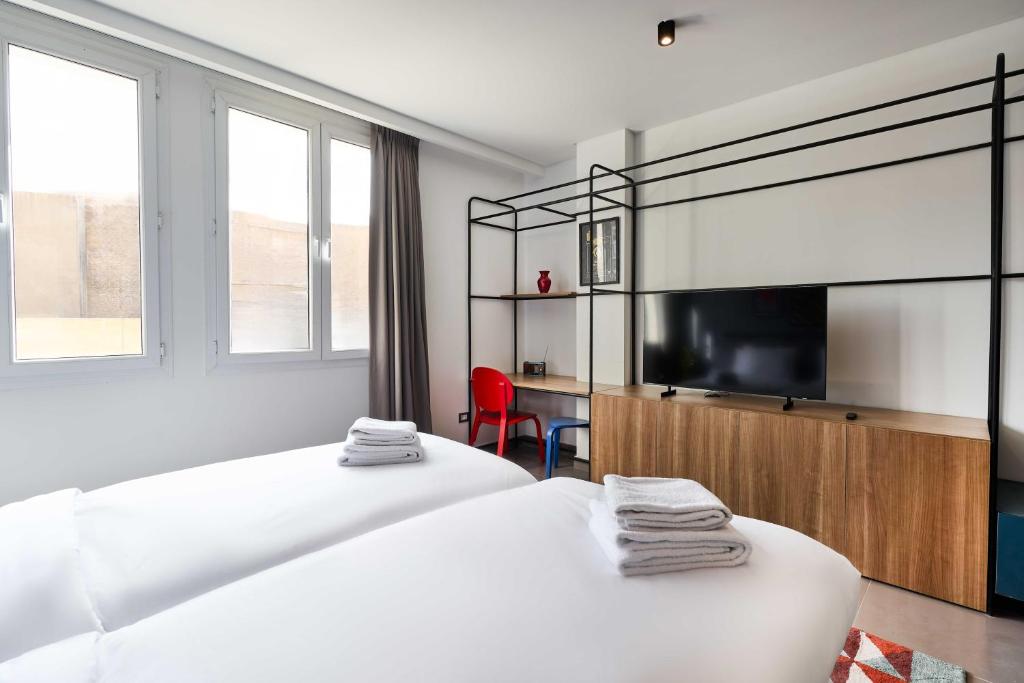 a bedroom with two beds and a flat screen tv at Brassbell l DT l Hannaux l Tahrir sq in Cairo