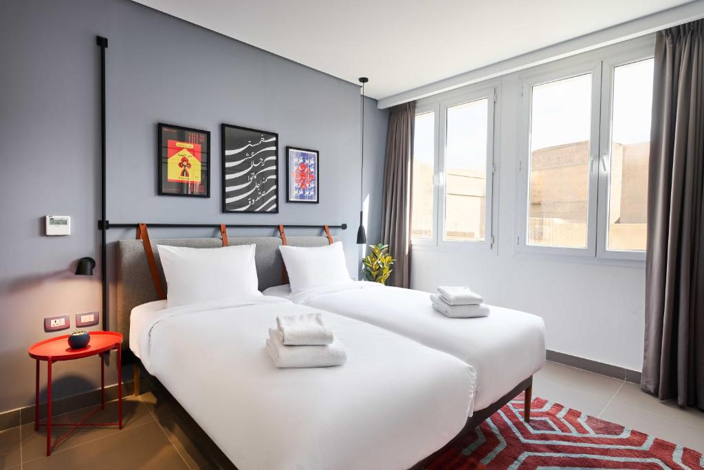 two white beds in a room with windows at Brassbell l DT l Hannaux l Tahrir sq in Cairo