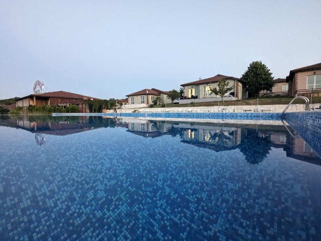 a large pool of blue water with houses in the background at Villa Emine in Banya