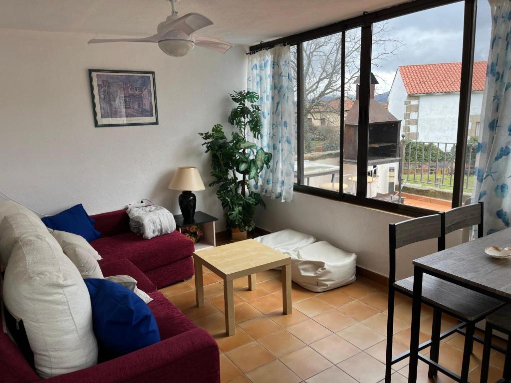 uma sala de estar com um sofá vermelho e uma mesa em Las Canchillas em La Carrera
