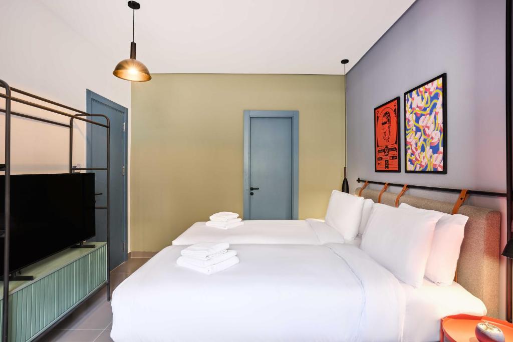 a bedroom with a large white bed and a tv at Brassbell l DT l Hannaux l Tahrir sq in Cairo