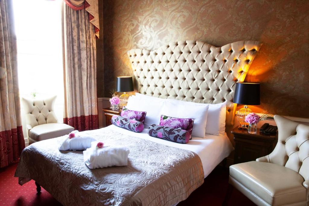 a hotel room with a bed with two towels on it at Greville Arms Hotel Mullingar in Mullingar