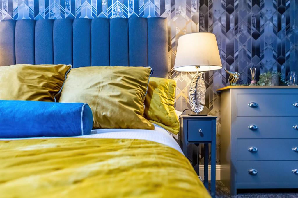a bed with a blue headboard next to a blue dresser at Room 07 - Sandhaven Rooms Double in South Shields