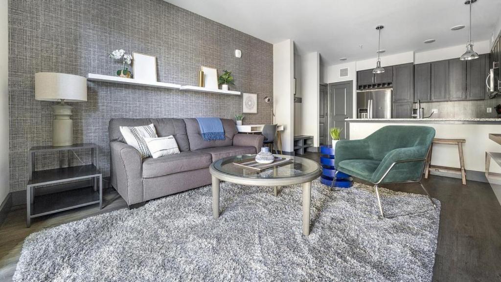 ein Wohnzimmer mit einem Sofa und einem Tisch sowie eine Küche in der Unterkunft Landing - Modern Apartment with Amazing Amenities (ID6298X53) in Parker