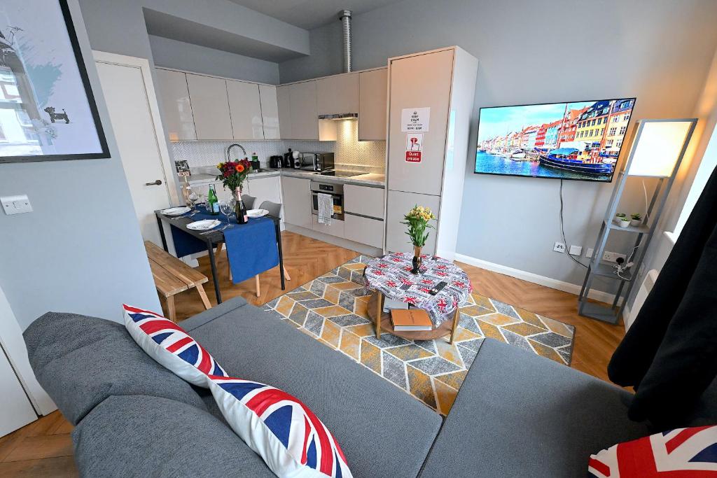 een woonkamer met een bank en een tafel en een keuken bij 1 BEDROOM FLAT IN WOOD GREEN PICCADILLY LINE in Londen