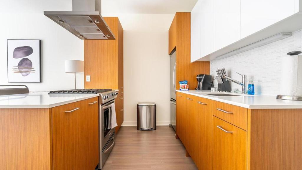 a kitchen with wooden cabinets and a stove top oven at Landing Modern Apartment with Amazing Amenities (ID1348X713) in Chicago