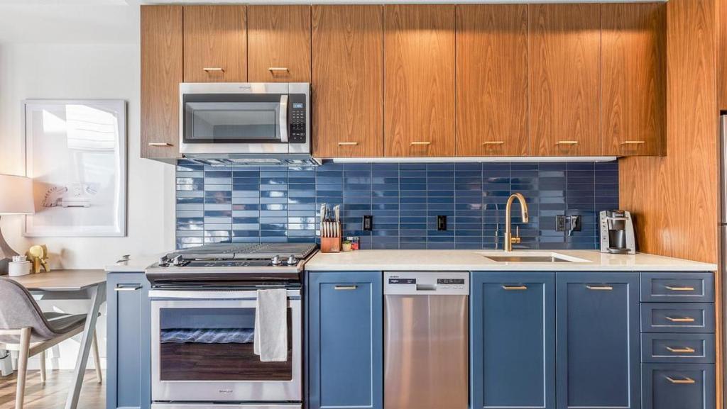 eine blaue Küche mit einer Spüle und einer Mikrowelle in der Unterkunft Landing Modern Apartment with Amazing Amenities (ID7082X14) in Portland