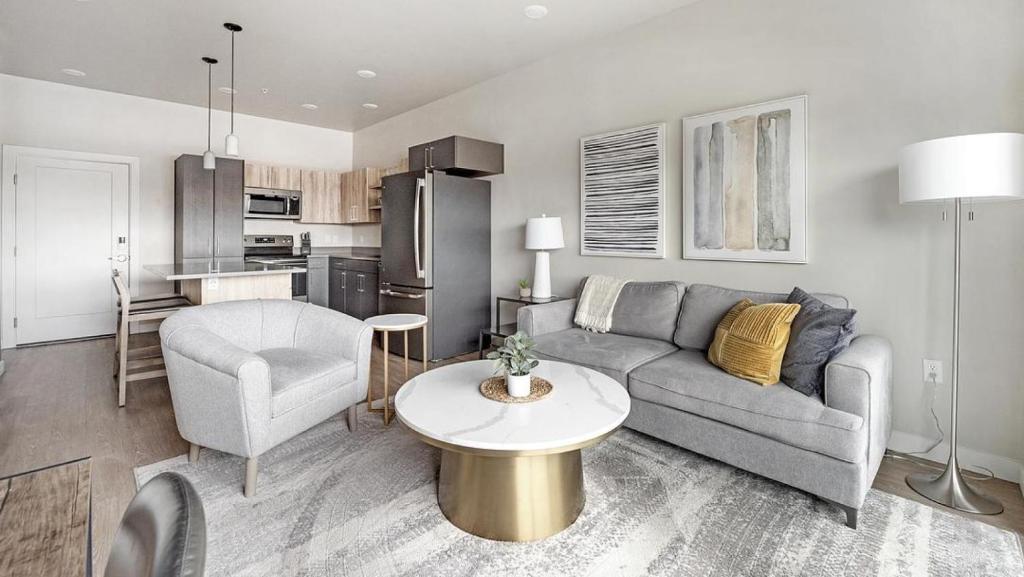 uma sala de estar com um sofá, uma mesa e uma cozinha em Landing - Modern Apartment with Amazing Amenities (ID7703X6) em Salt Lake City