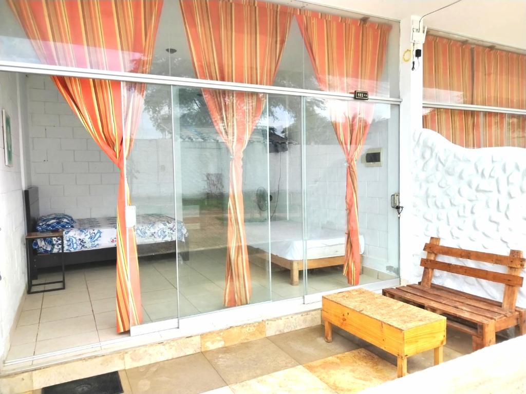 トゥンベスにあるZorritos Backpakersの窓(オレンジ色のカーテン、ベンチ付)が備わる客室です。
