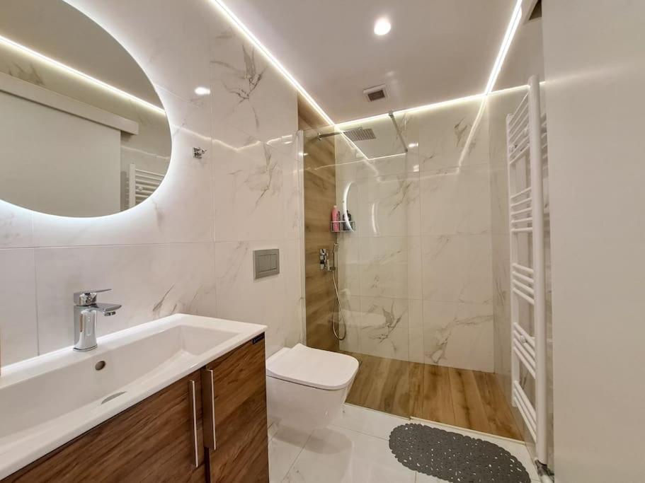 a bathroom with a sink and a toilet and a mirror at Luxury Suite Patras (2) in Patra
