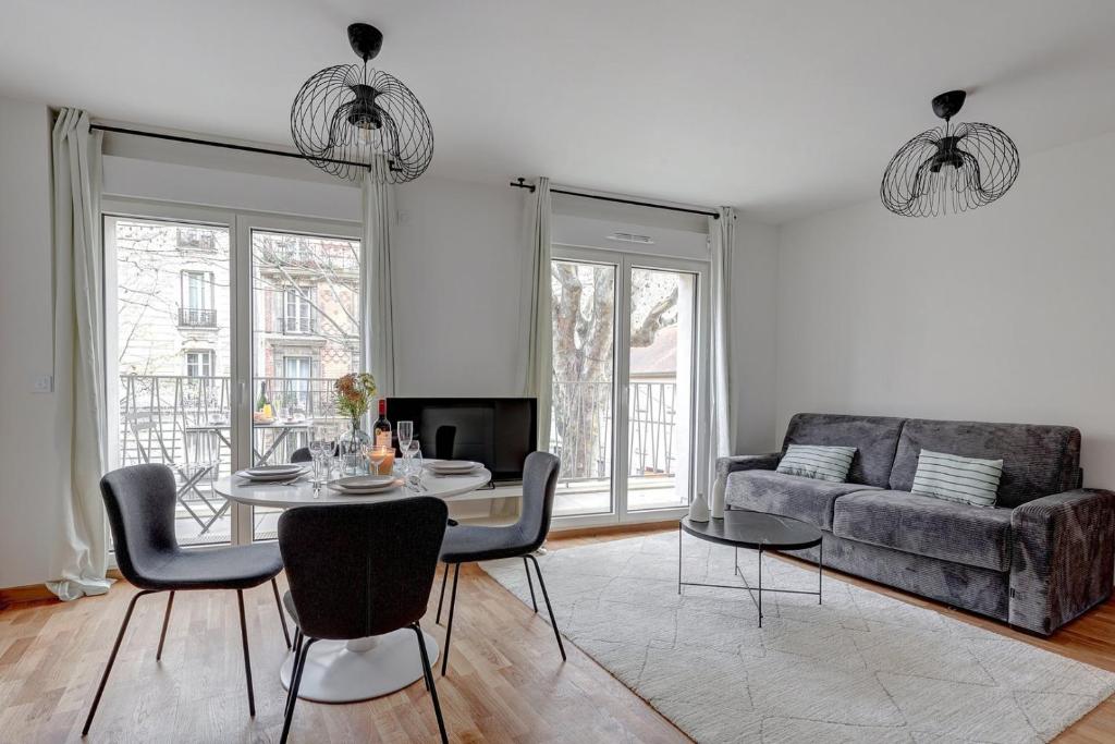 a living room with a table and a couch at 340 Suite Emile - Superb apartment in Clichy