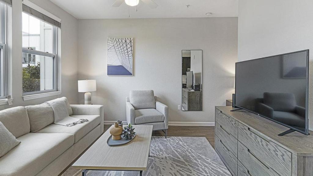un soggiorno con divano e TV a schermo piatto di Landing - Modern Apartment with Amazing Amenities (ID1326X971) a Kissimmee
