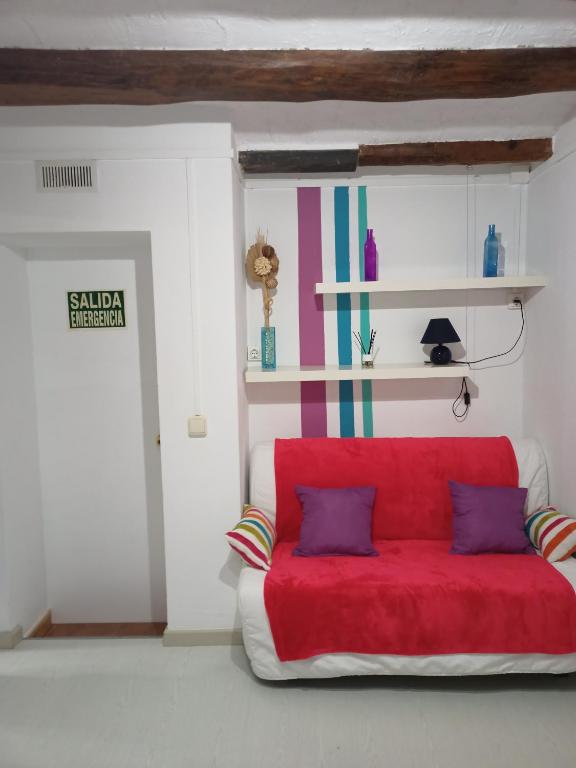 Hotel Estudio con balcon Plaza España, a red couch with two pillows in a room at Estudio con balcon Plaza España in Barcelona