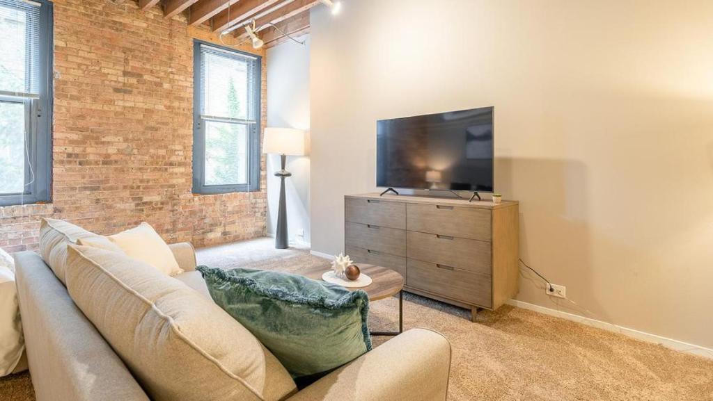 uma sala de estar com um sofá e uma televisão de ecrã plano em Landing - Modern Apartment with Amazing Amenities (ID5125X39) em Chicago