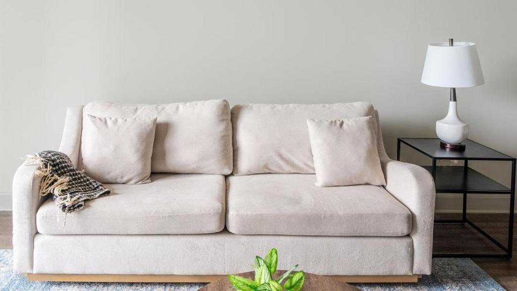ein weißes Sofa mit Kissen im Wohnzimmer in der Unterkunft Landing - Modern Apartment with Amazing Amenities (ID9847X59) in Cincinnati