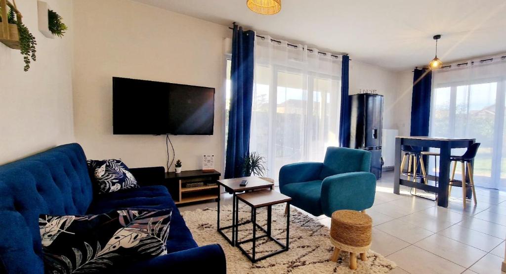 sala de estar con sofá azul y mesa en Le Paisible, en Douvaine