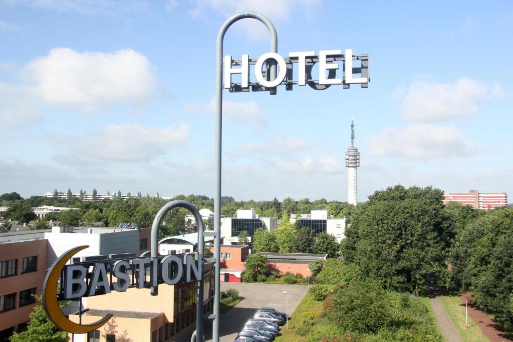 a hotel sign with a view of a city at Bastion Hotel Roosendaal in Roosendaal
