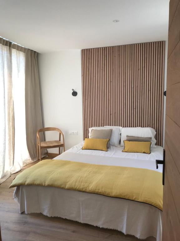 um quarto com uma cama grande e 2 almofadas amarelas em Lodge Valbelle em Tourves