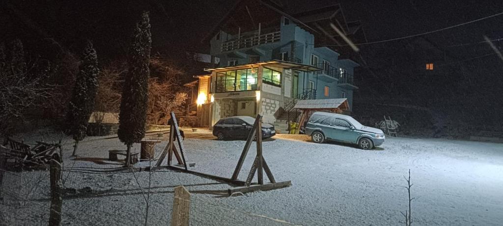 ein Auto, das nachts vor einem Gebäude parkt in der Unterkunft Casă de vacanţă ,,La Vălucu" in Curtea de Argeş