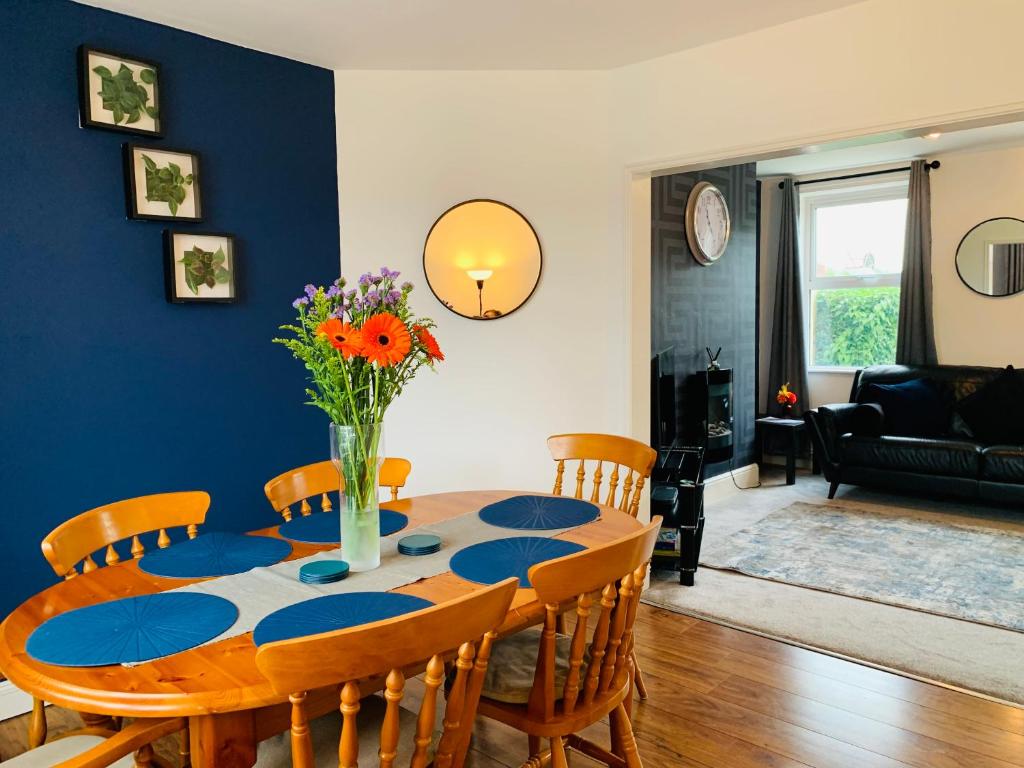 una sala da pranzo con tavolo e vaso di fiori di Chic 5 Bedroom House with Private Parking & Garden a Bristol