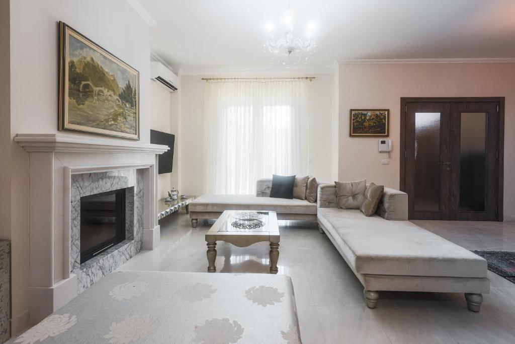 sala de estar con sofá y chimenea en The Urban Villa en Shkodër