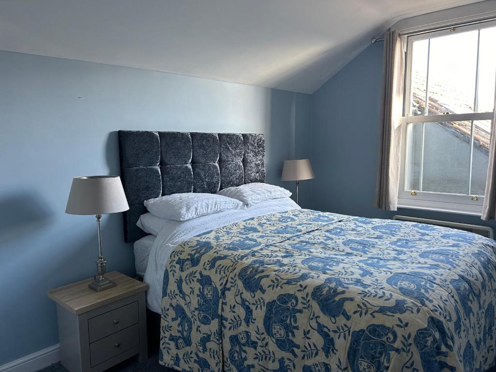 a blue bedroom with a bed and a window at Glengarth house Room only accommodation in Wells