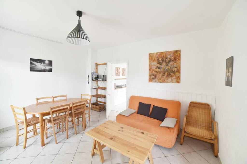 un salon avec un canapé et une table dans l'établissement Charmante maisonnette avec terrasse, à La Rochelle