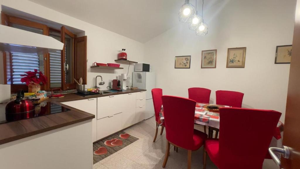 a kitchen with red chairs and a table in a kitchen at Itiseasy Cuglieri Luxury Apartments in Cuglieri