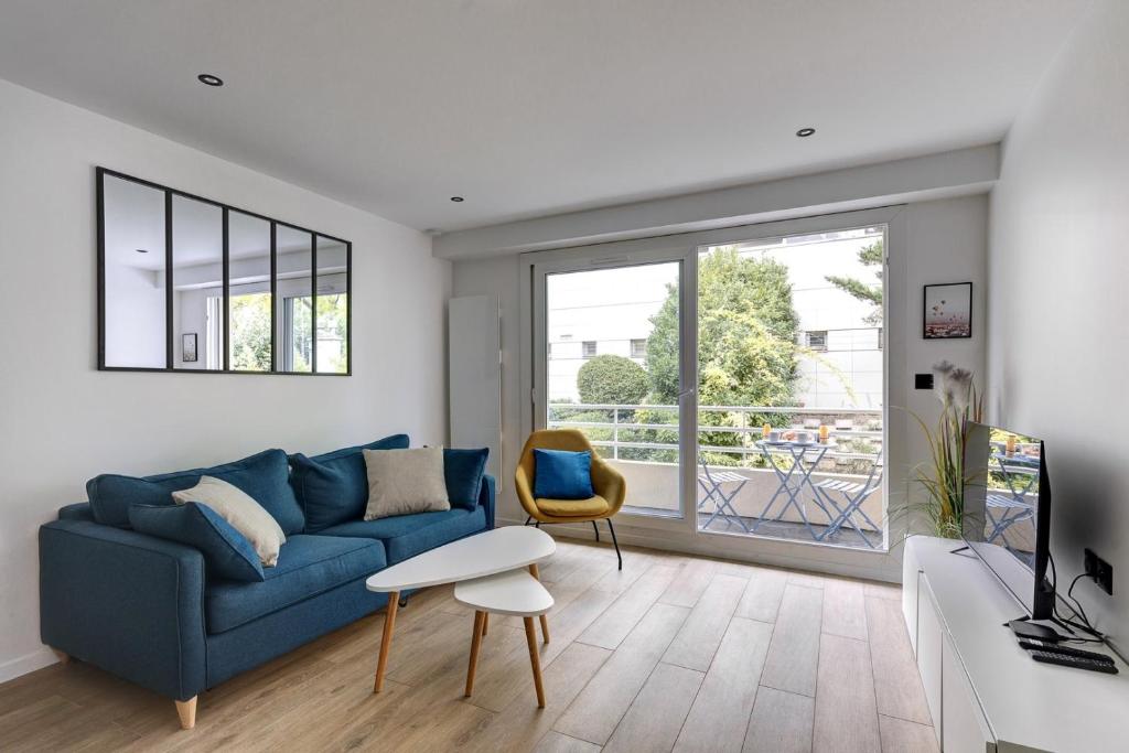 uma sala de estar com um sofá azul e uma janela em 322 Suite Fes - Superb apartment em Suresnes