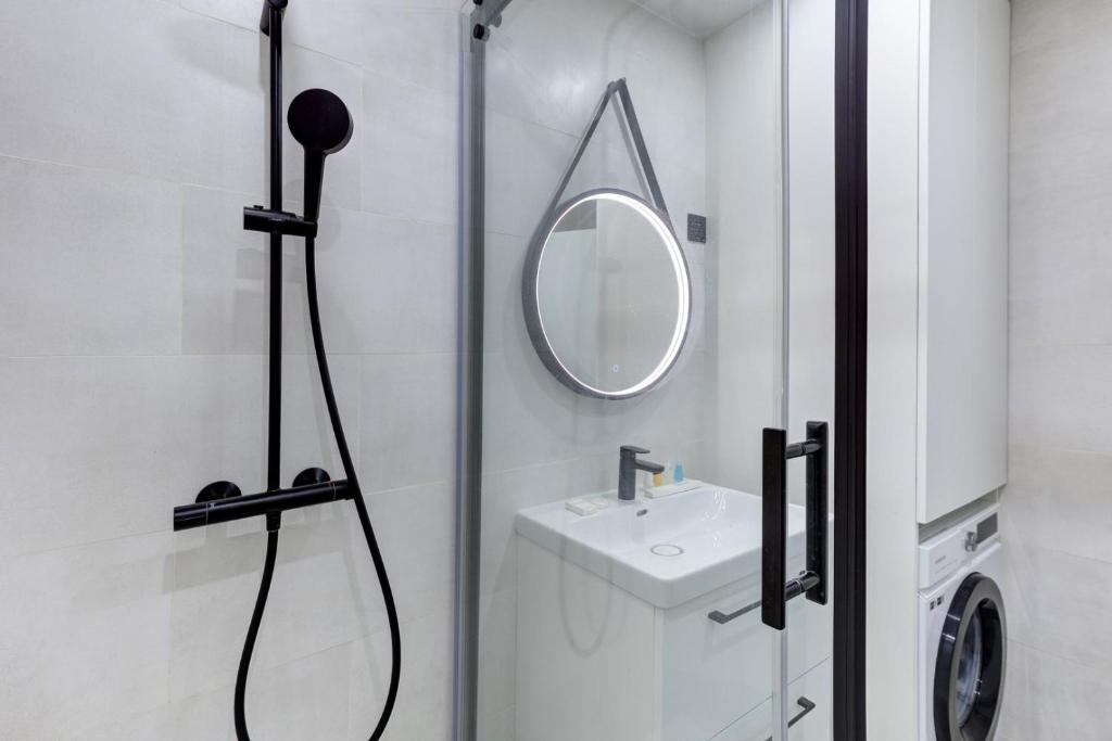 a bathroom with a shower with a sink and a mirror at 322 Suite Fes - Superb apartment in Suresnes