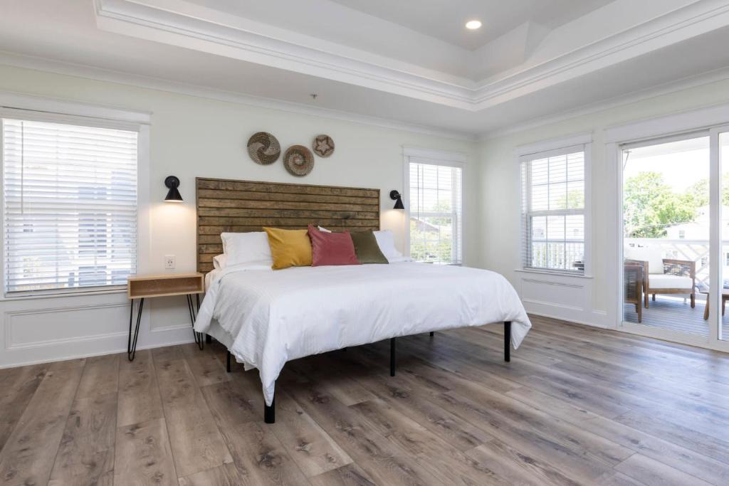 um quarto branco com uma cama grande e pisos em madeira em Avamere 206 Inn at Old Beach em Virginia Beach