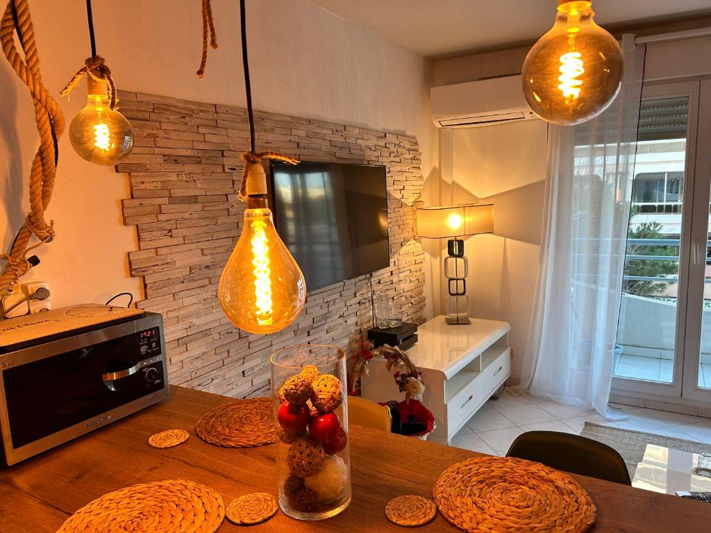 eine Küche mit einem Holztisch mit Lampen darüber in der Unterkunft LaMer in Juan-les-Pins