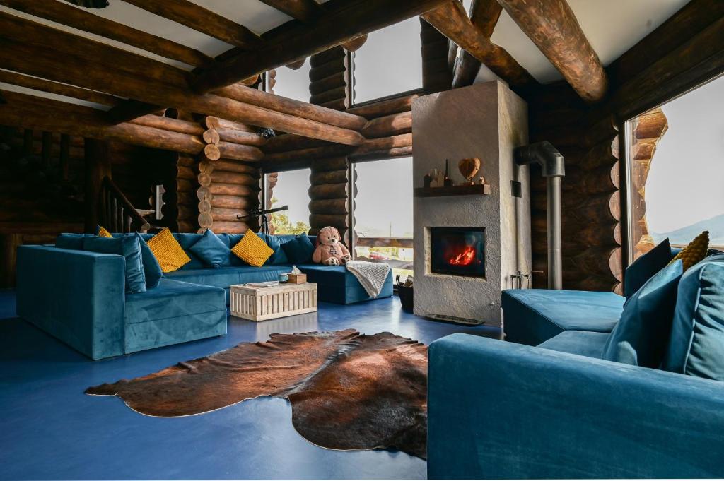 a living room with blue couches and a fireplace at The Barn in Şirnea