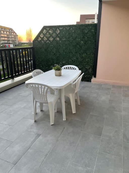 une table blanche et des chaises sur un balcon dans l'établissement Résidence Deauville 2000 à 50m plage, à Villers-sur-Mer