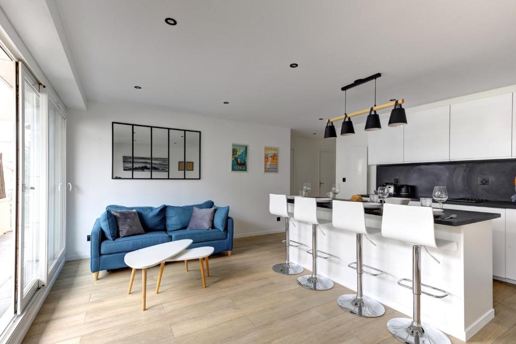 Il comprend un salon avec un canapé bleu et une cuisine. dans l'établissement 320 Dolce Vita Suite - Superb apartment, à Suresnes