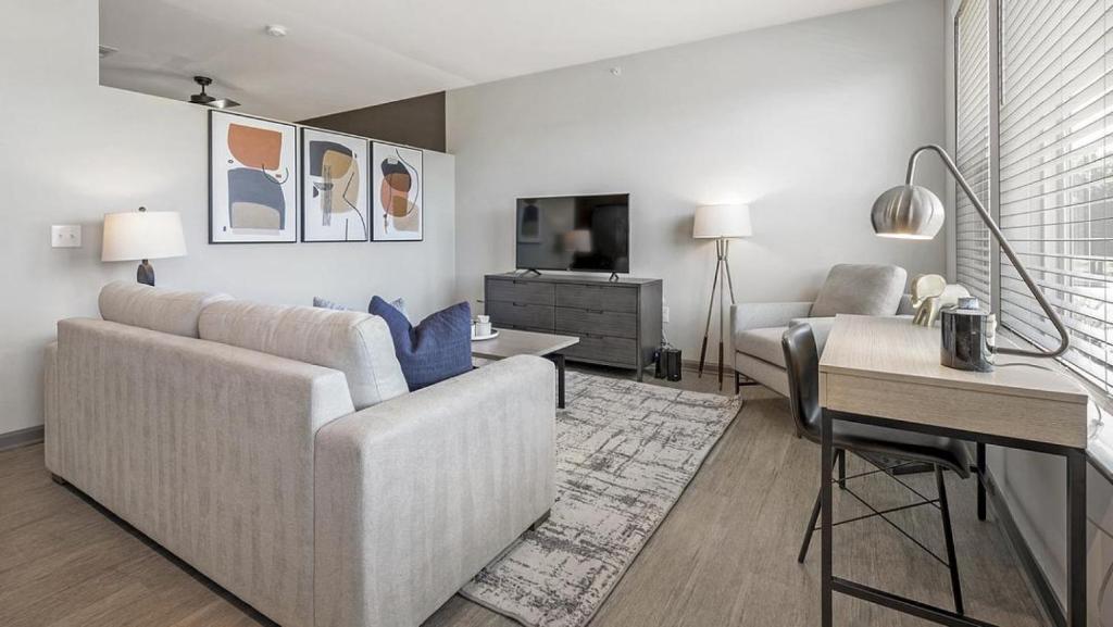 ein Wohnzimmer mit einem Sofa und einem Tisch in der Unterkunft Landing - Modern Apartment with Amazing Amenities (ID1208X248) in Charlotte