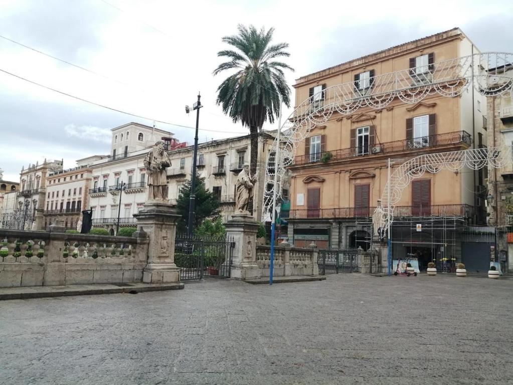 a city square with a palm tree and buildings at Da Ale alla Cattedrale in Palermo