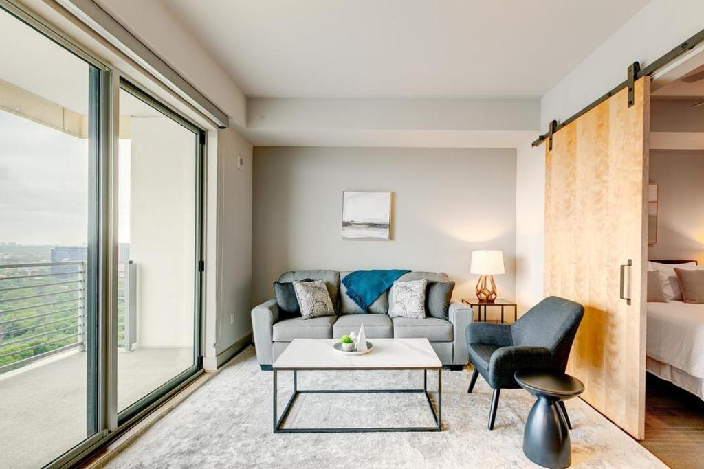 Landing - Modern Apartment with Amazing Amenities (ID4772X11) في دالاس: غرفة معيشة مع أريكة وطاولة