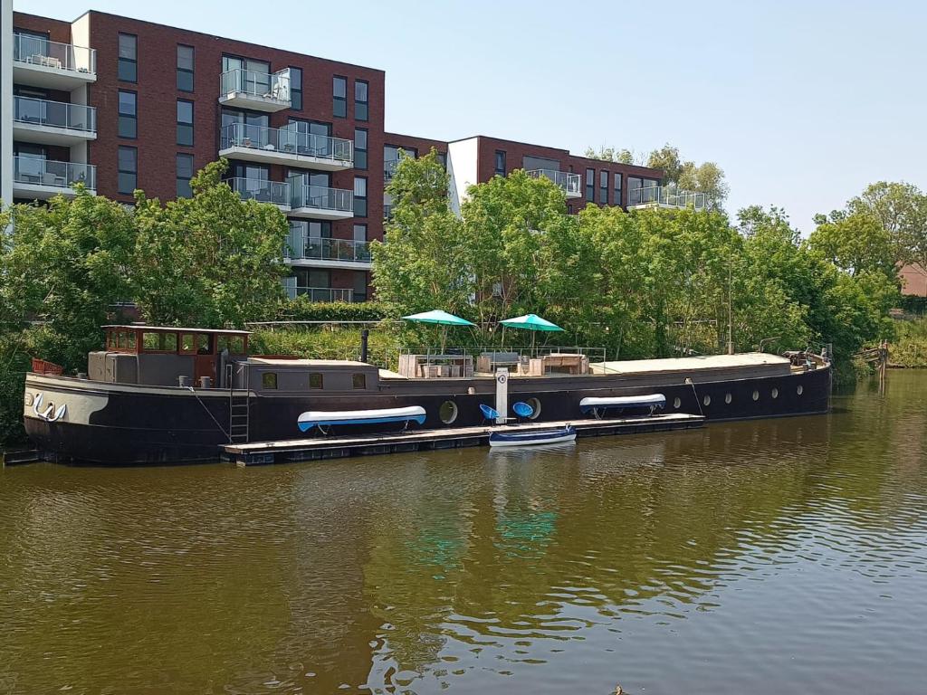 Ein Boot mit Sonnenschirmen liegt auf dem Wasser. in der Unterkunft Bed in Boat in Ypern