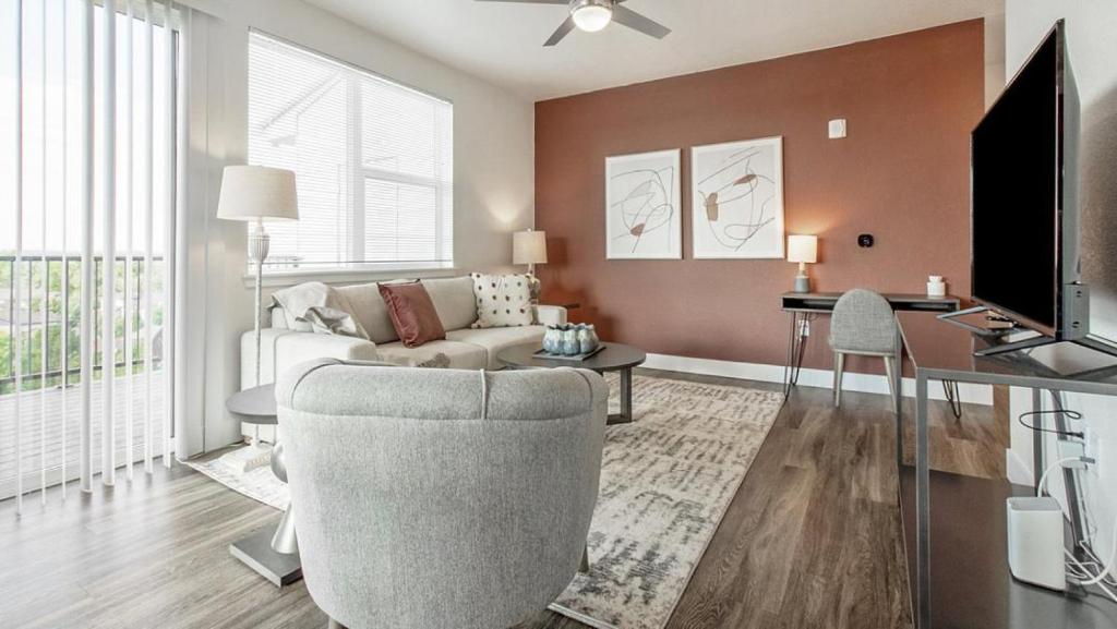 uma sala de estar com um sofá, uma secretária e uma televisão em Landing - Modern Apartment with Amazing Amenities (ID5507X06) em Denver