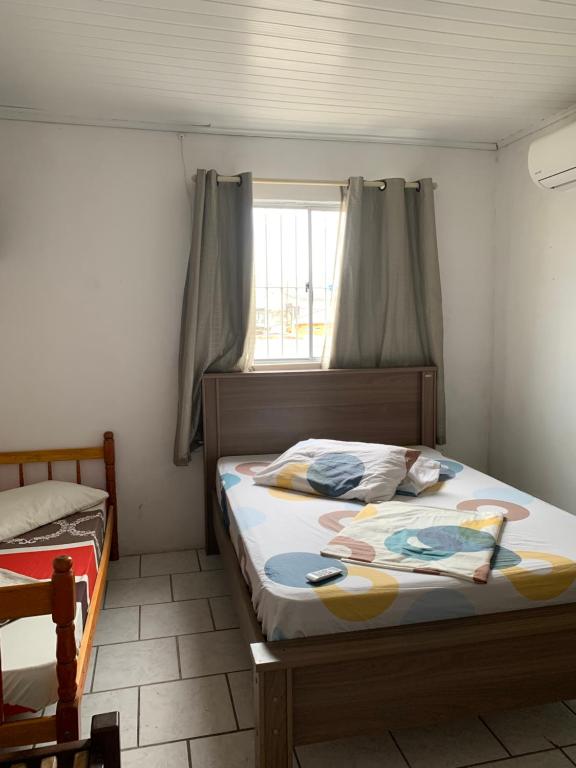 1 dormitorio con 2 camas y ventana en Pousada Brum en Pelotas