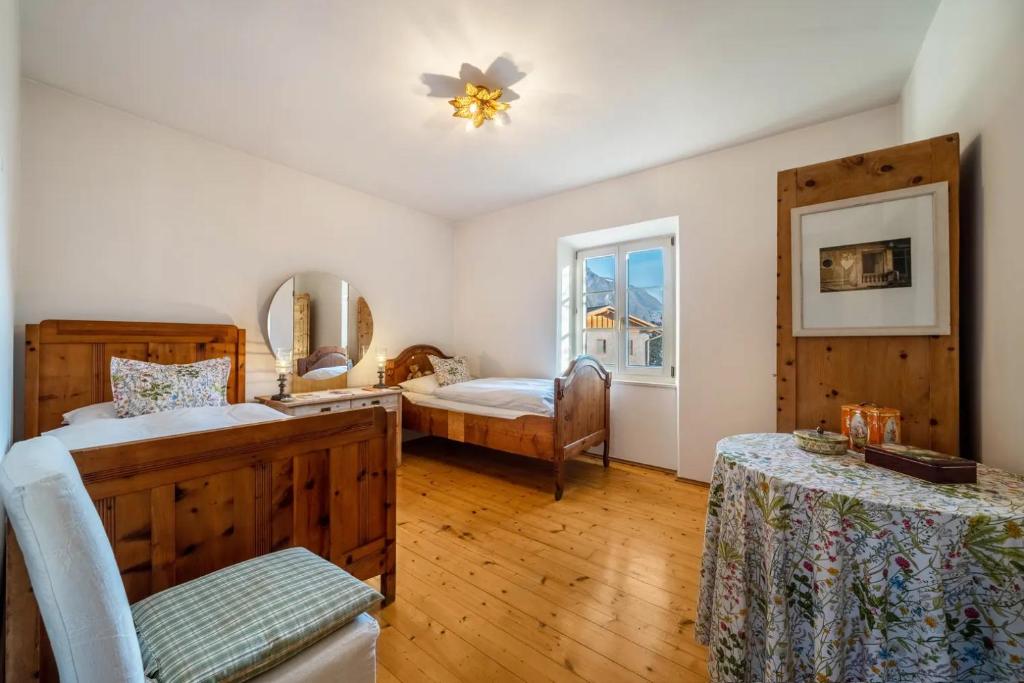 1 dormitorio con 2 camas, silla y ventana en APARTMENT im garten 9, en Gargazzone