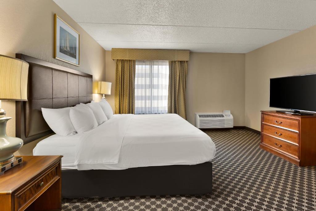 um quarto de hotel com uma cama e uma televisão de ecrã plano em Hotel RL Cleveland Airport West em North Olmsted