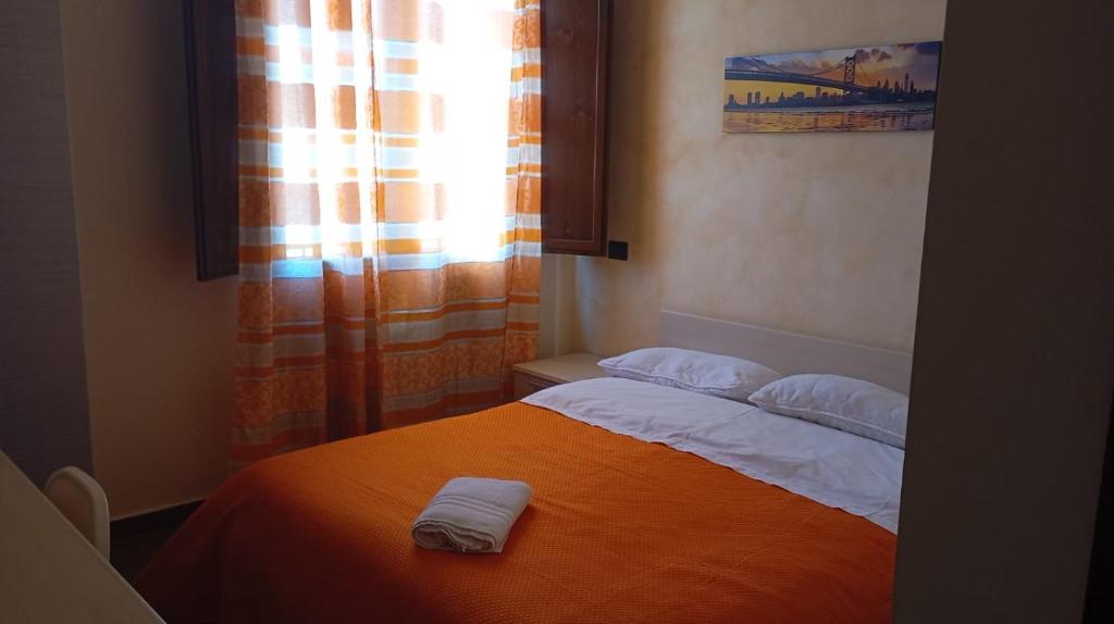 una camera da letto con un letto e due asciugamani di T'Addormento a Reggio di Calabria