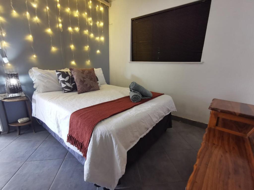 a bedroom with a bed with lights on the wall at Feather Rest in Bloemfontein