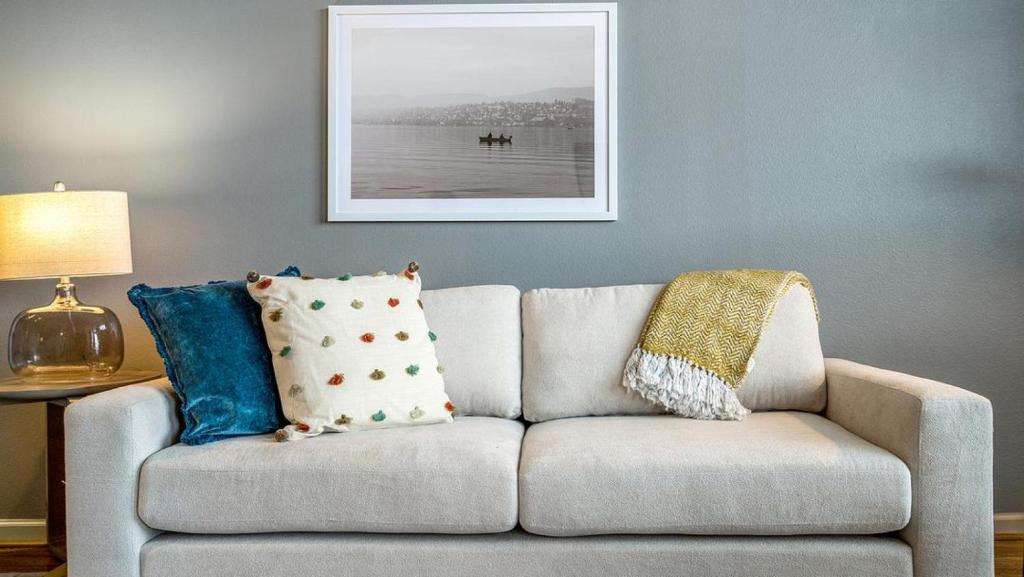 a couch with pillows on it in a living room at Landing - Modern Apartment with Amazing Amenities (ID8403X71) in Garland